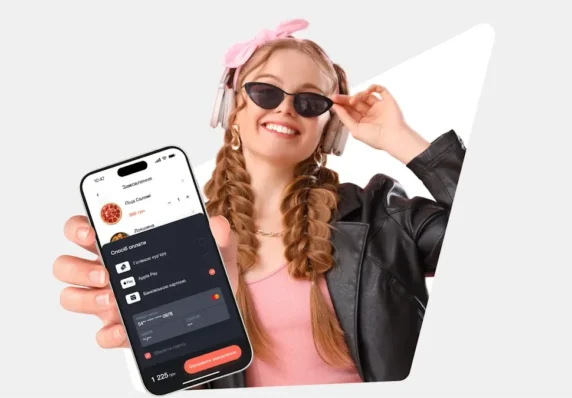 Дівчина показує сторінку оплати від сервісу hutko на своєму смартфоні