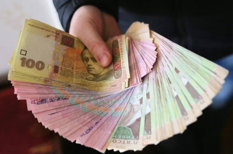 банкноти гривні в руці